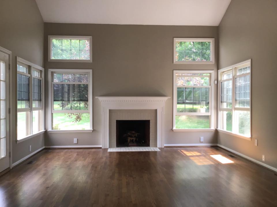 large empty room with 6 windows surrounding fireplace