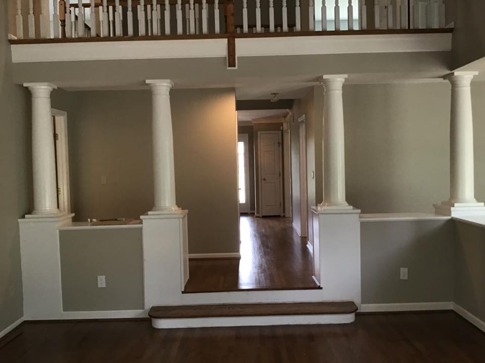 empty room with 4 white columns with grey walls and white trim, wood floors