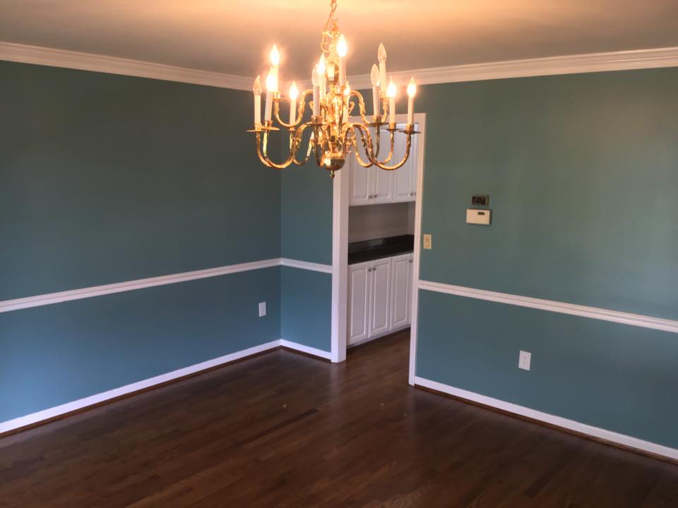 empty room with chandelier and blue walls with white trim