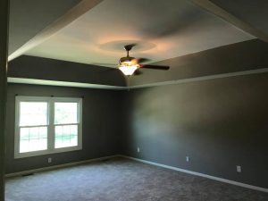 empty room with window and ceiling fan with grey walls, white trim