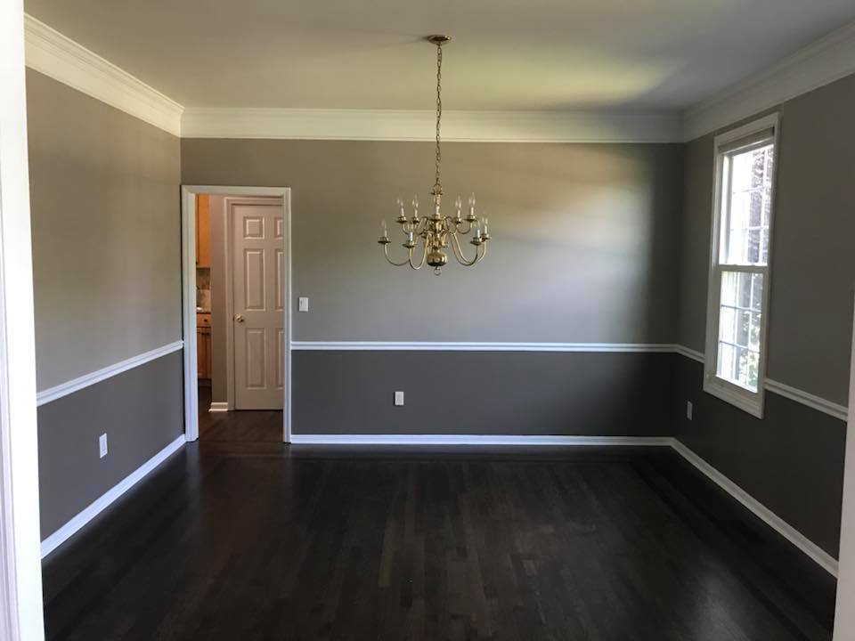 empty room with chandelier, two toned grey walls with white trim